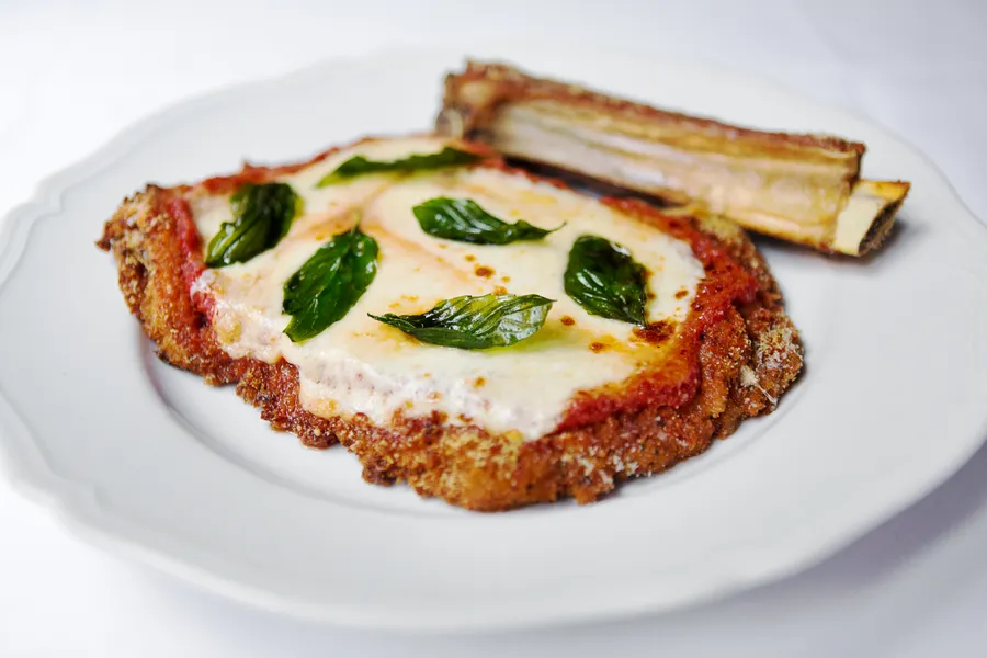 Carbone Vino signature dishes Spicy Rigatoni Vodka, Veal Parmesan, and tableside-prepared Caesar Salad.